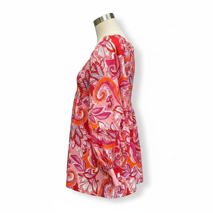Chic Collective babydoll top with a vibrant pink, red, and orange paisley print. Features a smocked bust and balloon sleeves.