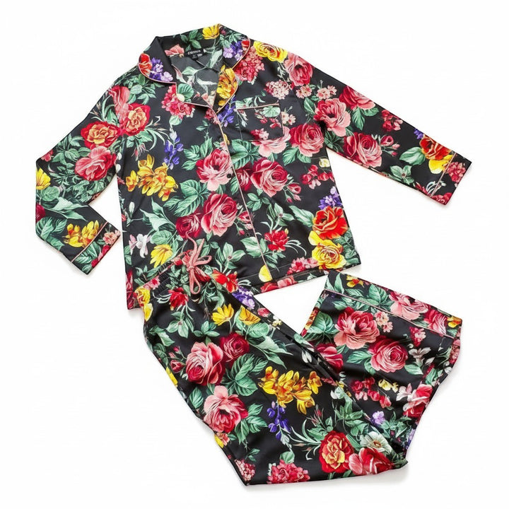 Chic Collective black satin pajama set with a vibrant floral print, featuring a collared button-up top and drawstring pants.