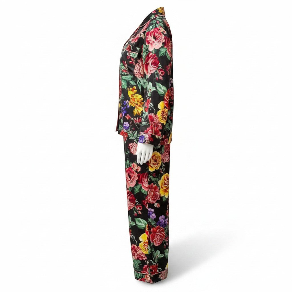 Chic Collective black satin pajama set with a vibrant floral print of red, yellow, and pink roses. Features a collared neckline and long sleeves.