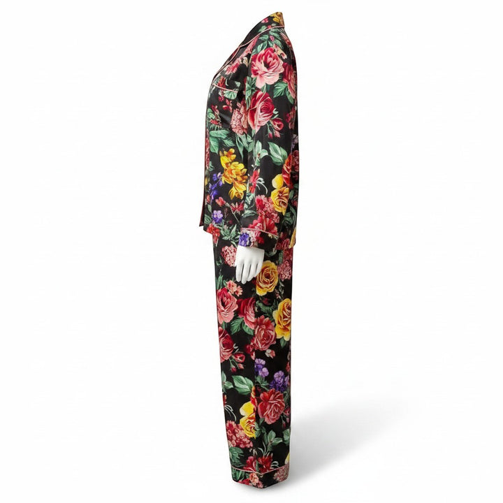 Chic Collective black satin pajama set with a vibrant floral print of red, yellow, and pink roses. Features a collared neckline and long sleeves.