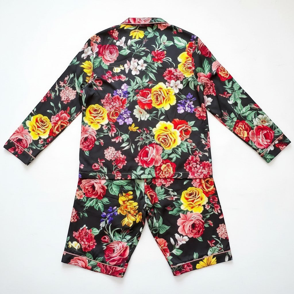 Chic Collective black satin pajama set with a vibrant floral print. Features a collared long-sleeve top and shorts.
