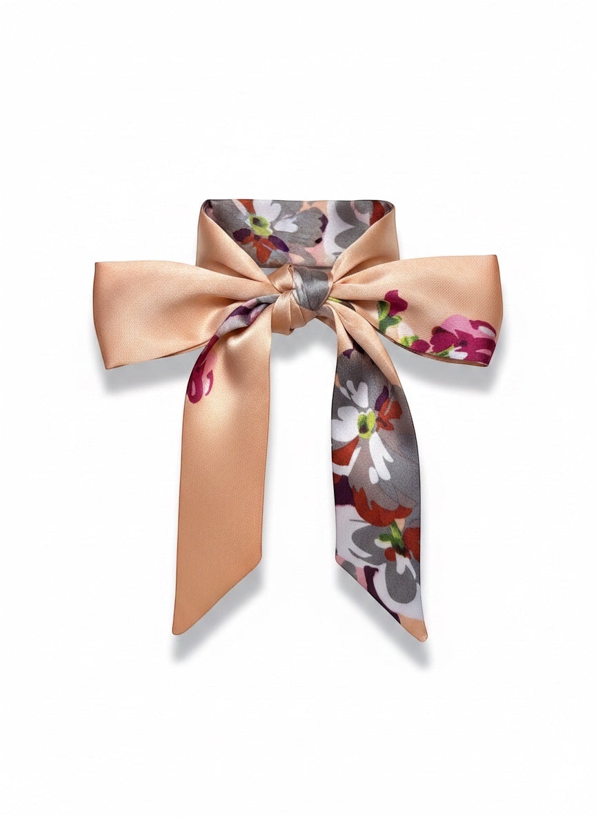 Chic Collective Blush Bloom Ribbon Tie, a satin scarf with floral print and peach solid ends, tied in a bow.