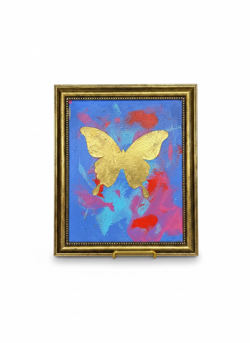 Chic Collective Celestial Flight framed art: gold butterfly on blue, pink, and coral abstract background.