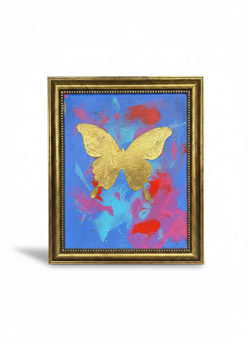 Chic Collective Celestial Flight framed art: gold butterfly on abstract blue, pink, and coral background with gold leaf detail.