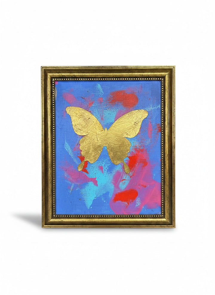 Chic Collective Celestial Flight framed art: gold butterfly on abstract blue, pink, and coral background with gold leaf detail.