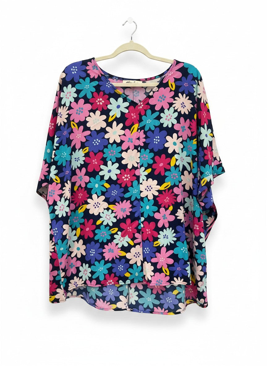 Chic Collective navy blue kaftan top with a vibrant floral print in pink, blue, and yellow. Features a V-neck and flowy sleeves.