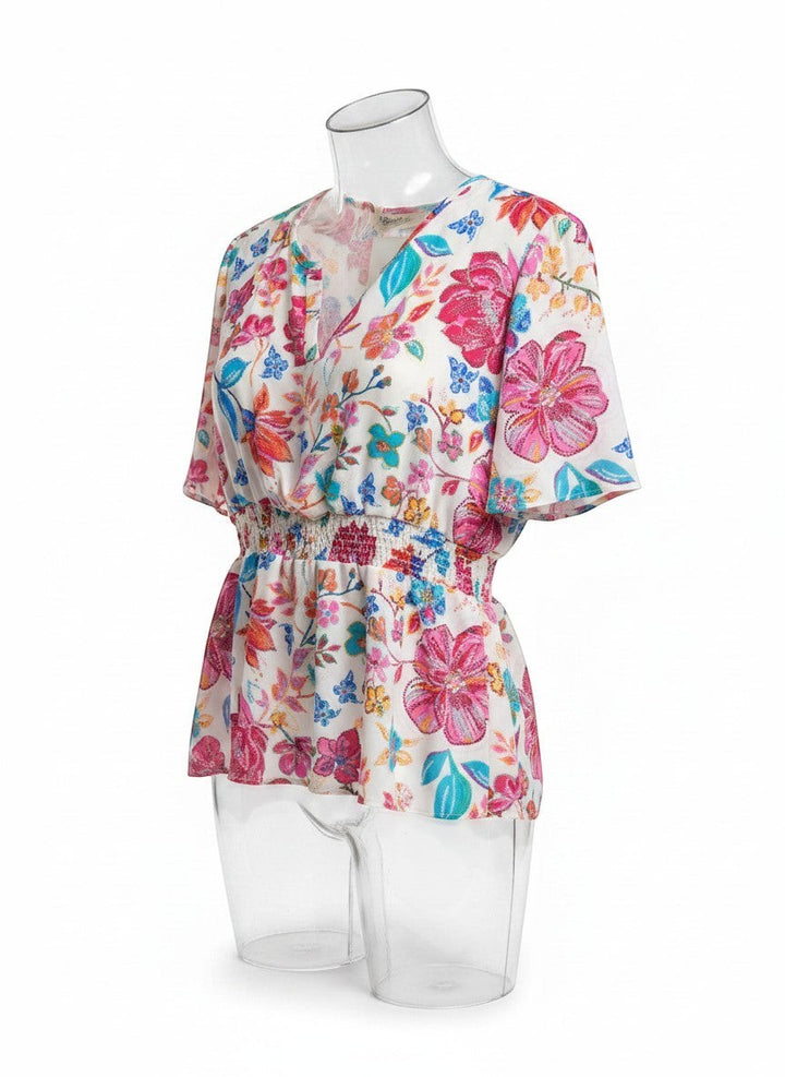 Chic Collective floral print blouse with ivory, hot pink, and blue flowers, featuring a V-neck and smocked waist.