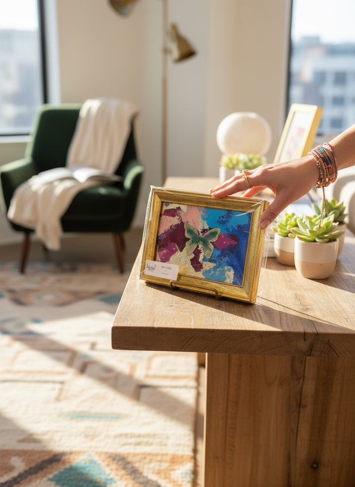 Chic Collective Flutter &amp; Bloom framed artwork with a green butterfly on abstract blue, plum, pink, and gold background.