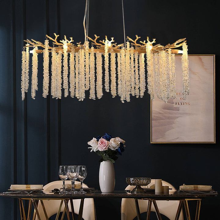 Chic Collective modern gold rectangular chandelier with cascading crystal strands and branch-like accents, ideal for dining rooms.