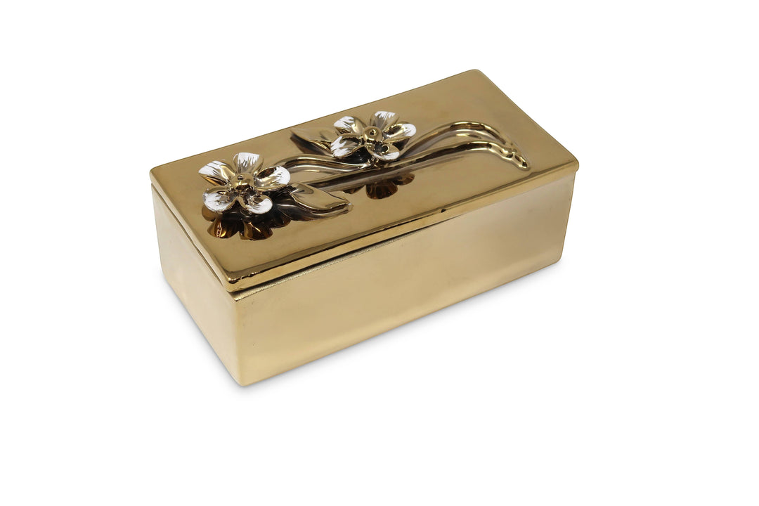 Chic Collective oblong gold decorative box with embossed white and gold flower design on lid. Metal, 6"L x 3"W x 3"H.