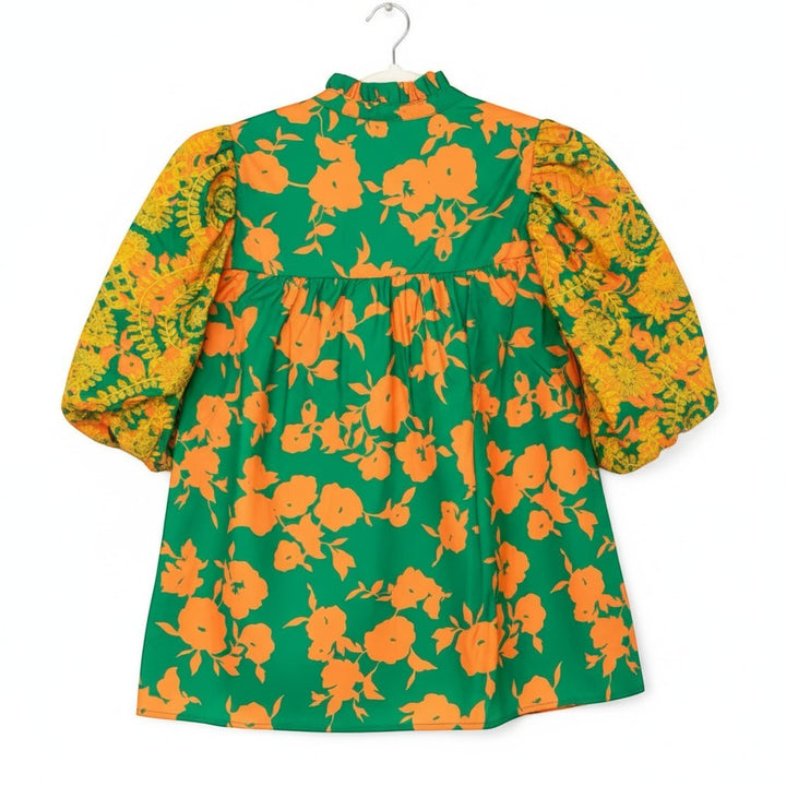 Chic Collective green dress with orange floral print and contrasting yellow embroidered sleeves. High neck with ruffled collar and puff sleeves.