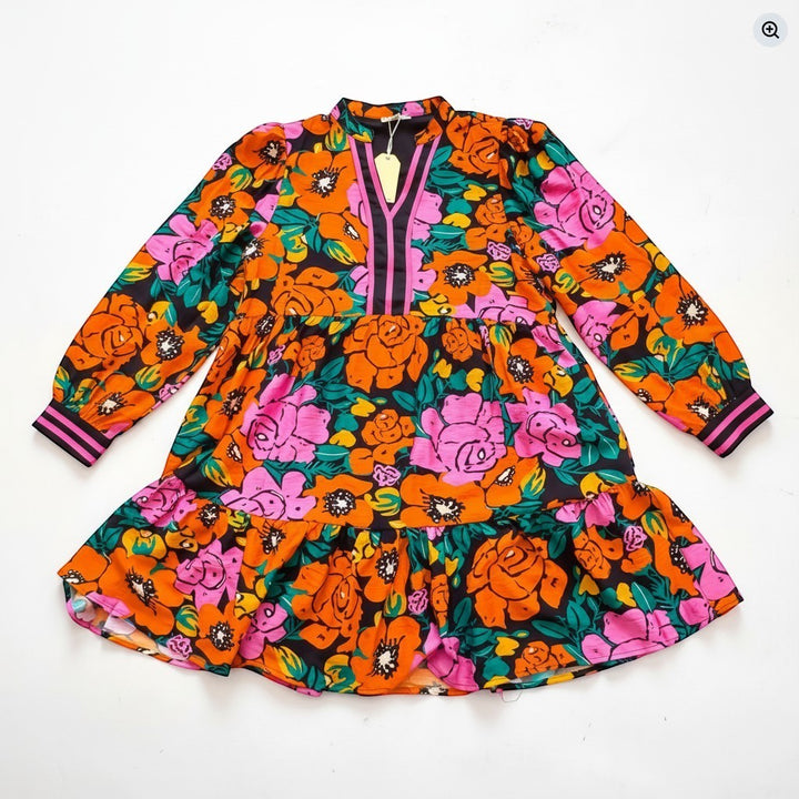 Chic Collective JODIFL dress with a vibrant floral print in orange, pink, and green on a black background. Features a V-neck, long sleeves, and a tiered skirt.