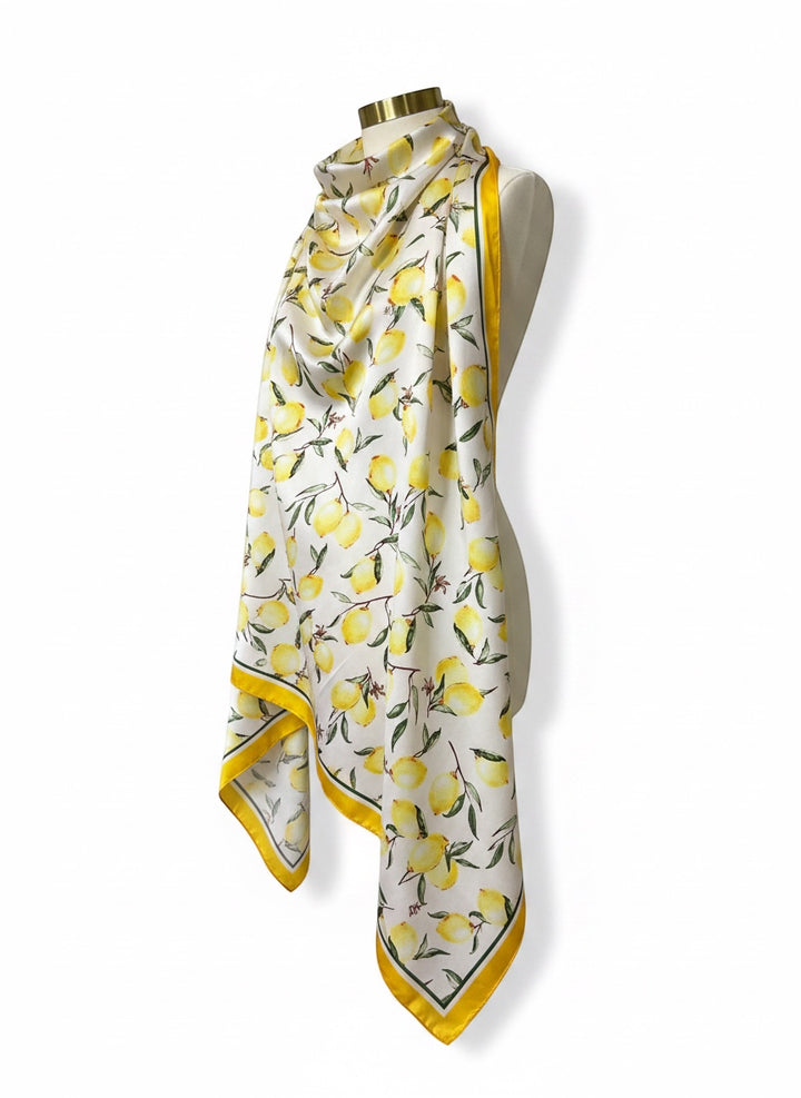 Chic Collective ivory satin scarf with a watercolor lemon and green leaf print and a yellow border.
