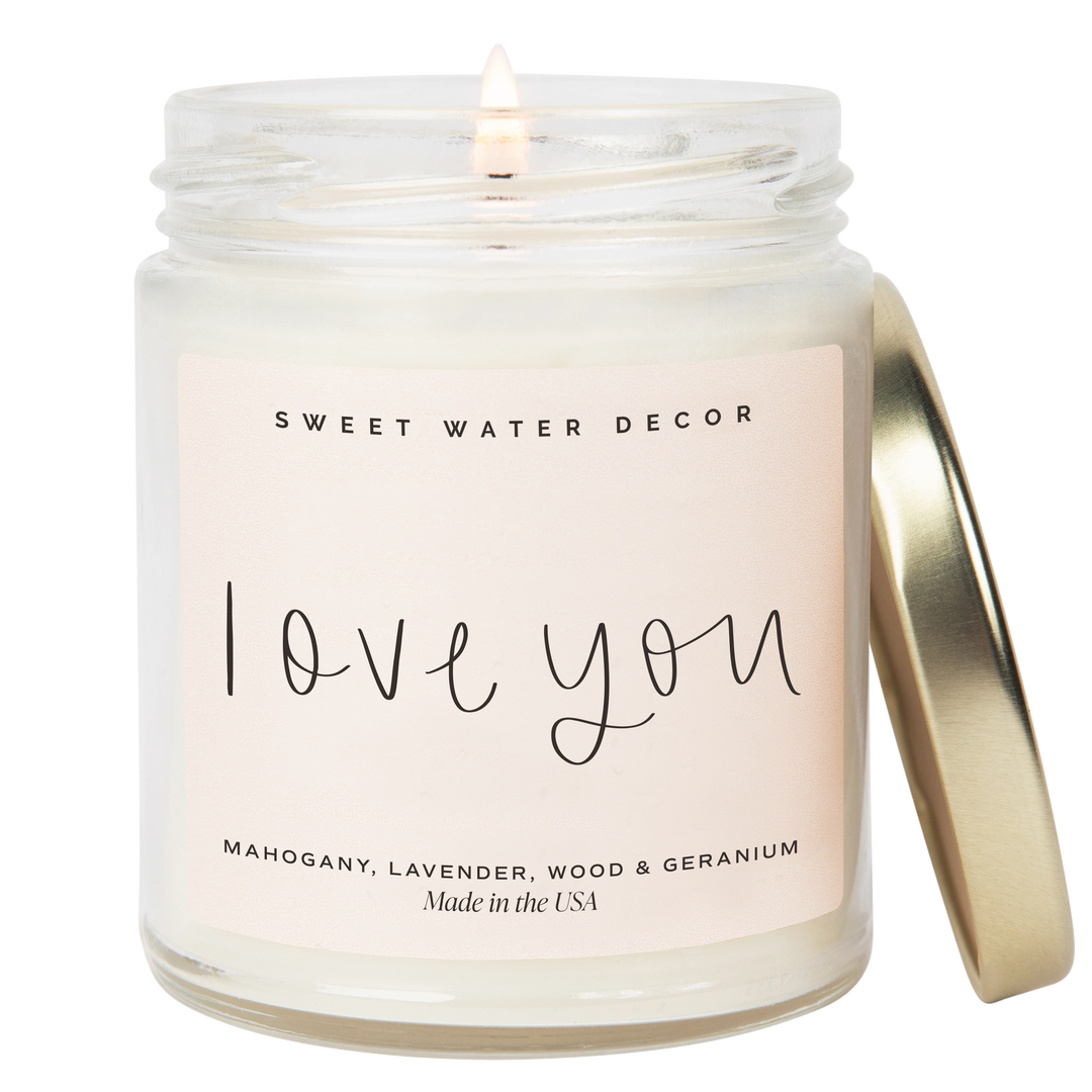 Chic Collective Love You 9 oz soy candle with driftwood and mahogany scent, featuring a light pink label and gold lid.