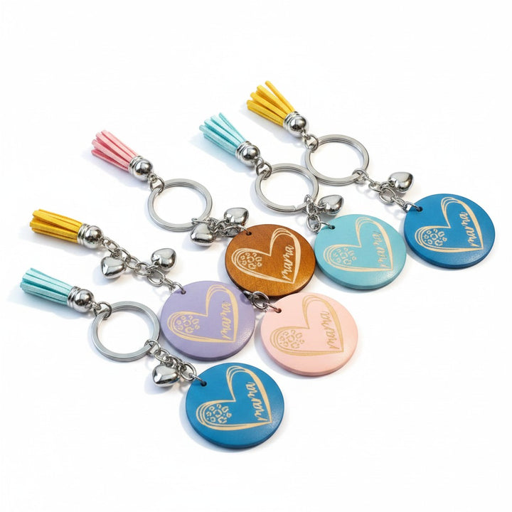 Chic Collective Mama keychain with colorful tassels and heart charm. Available in pink, blue, yellow, purple, and natural wood.