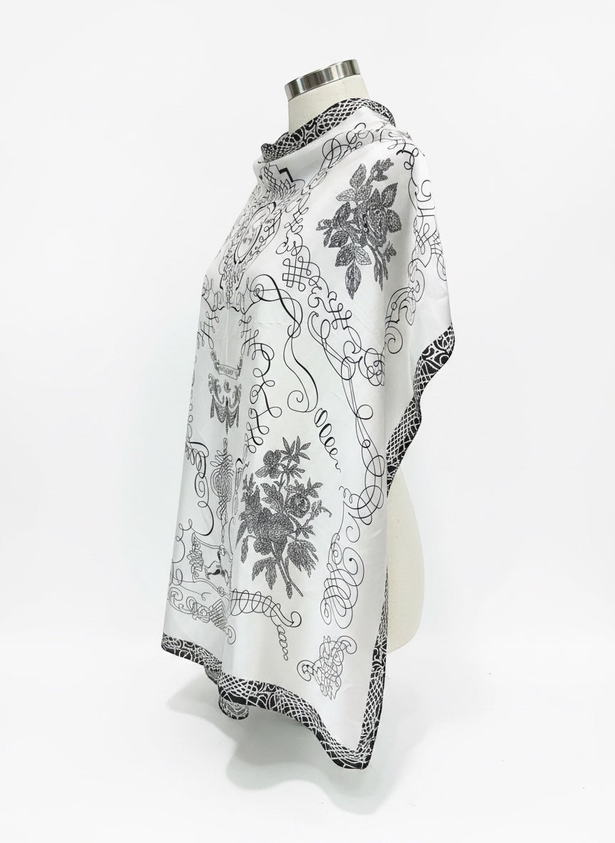 Chic Collective The Midnight Manor Scarf: elegant ivory satin with black ornamental detailing and floral motifs.