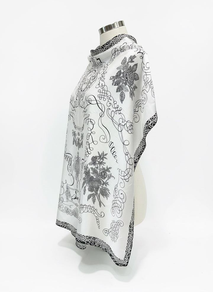 Chic Collective The Midnight Manor Scarf: elegant ivory satin with black ornamental detailing and floral motifs.