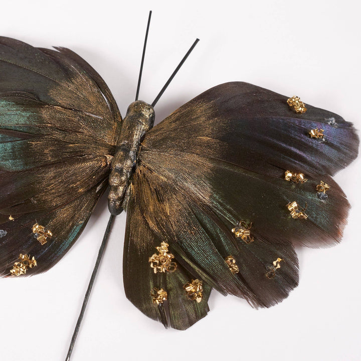 Chic Collective Moody Butterfly pick set with dark feathers, gold accents, and glitter details on a wire pick.