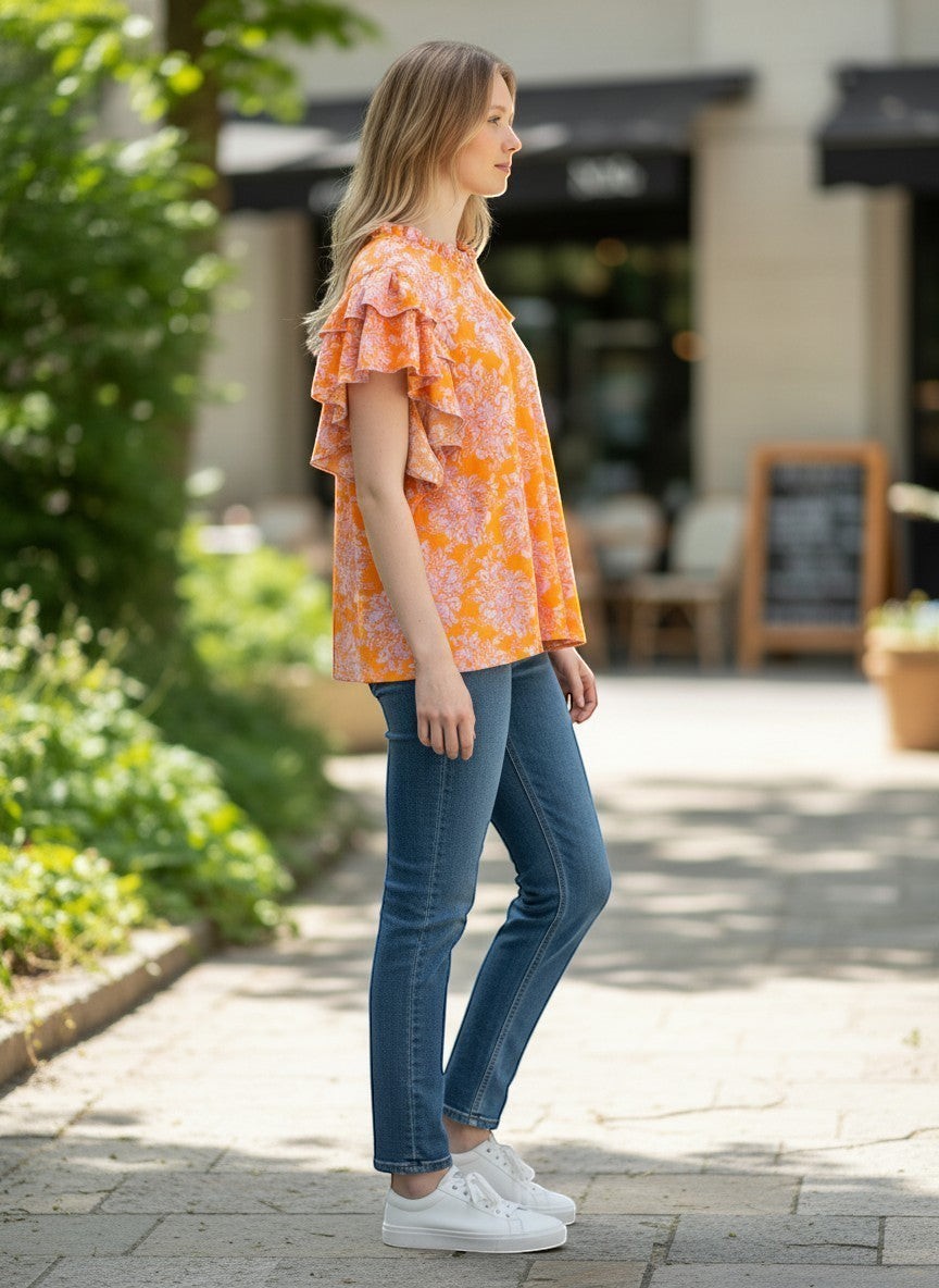 Chic Collective orange lilac floral mock neck double layered ruffle top worn by a woman outdoors.