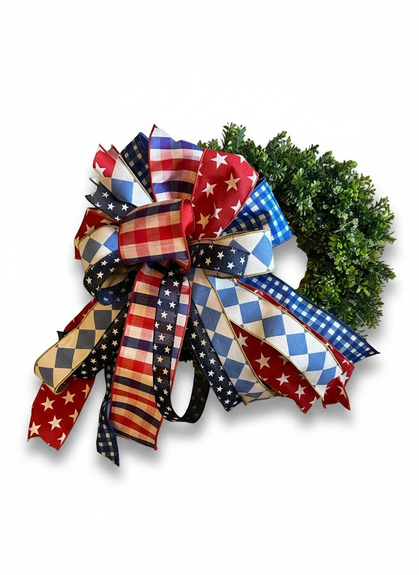 Chic Collective patriotic decorative bow with red, white, and blue stars, stripes, gingham, and diamond patterns on a wreath.