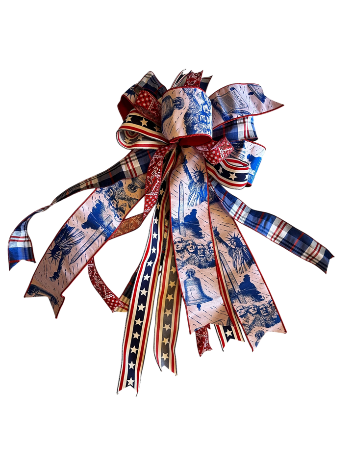Chic Collective patriotic bow with Statue of Liberty, Mount Rushmore, and Liberty Bell prints. Red, white, and blue plaid.