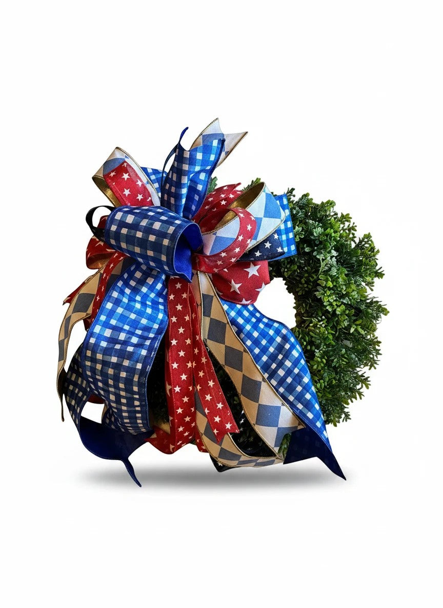 Chic Collective patriotic bow with red, white, and blue ribbons featuring stars and gingham patterns on a green wreath.