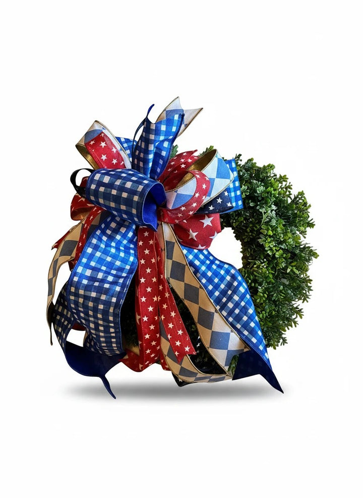 Chic Collective patriotic bow with red, white, and blue ribbons featuring stars and gingham patterns on a green wreath.