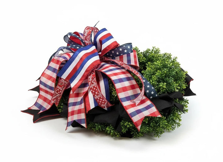 Chic Collective patriotic boxwood wreath with red, white, and blue striped, gingham, and star-patterned ribbons.