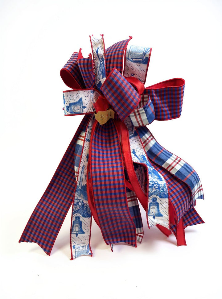 Chic Collective patriotic ribbon bow with red, white, and blue plaid and Liberty Bell patterns for holiday decor.