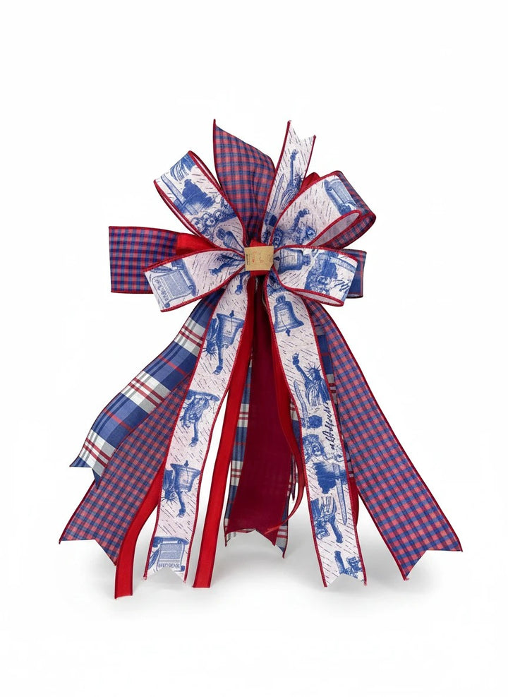 Chic Collective patriotic ribbon bow with red, white, and blue plaid and Liberty Bell patterns for holiday decor.