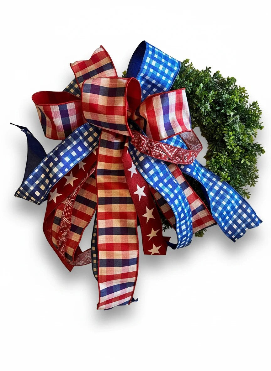 Chic Collective patriotic ribbon bow with red, white, and blue gingham and star patterns on a greenery wreath.