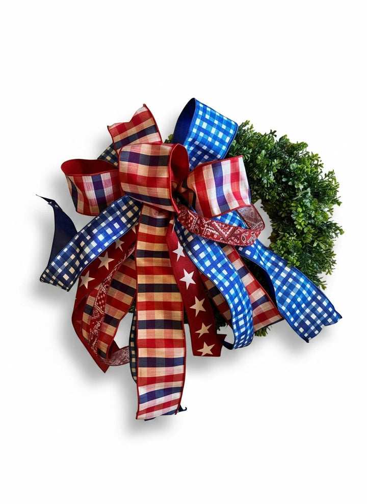 Chic Collective Patriotic ribbon bow with red, white, and blue gingham and star patterns on a green wreath.