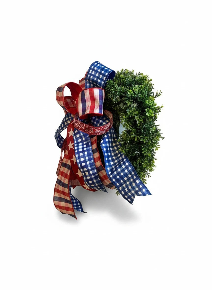 Chic Collective patriotic ribbon bow with red, white, and blue gingham and stars on a greenery wreath.