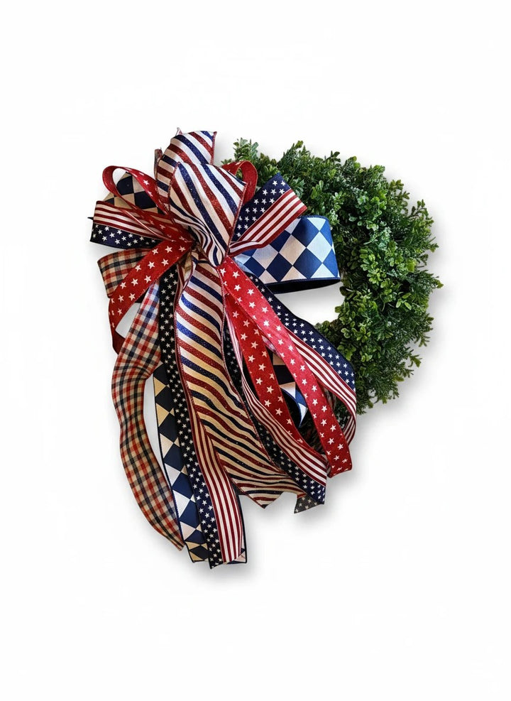 Chic Collective patriotic wreath with a large bow made of red, white, and blue ribbons featuring stars, stripes, and checkered patterns.