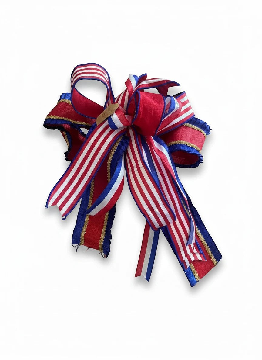 Chic Collective patriotic decorative bow featuring red, white, and blue striped ribbon with gold trim edges.