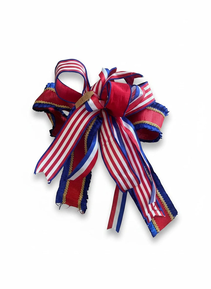 Chic Collective patriotic decorative bow featuring red, white, and blue striped ribbon with gold trim accents.