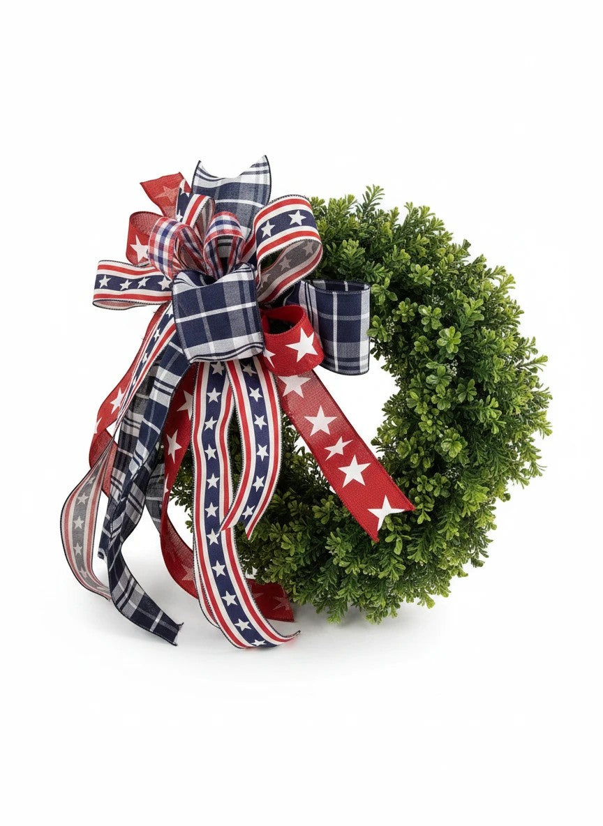 Chic Collective patriotic bow with red, white, and blue plaid and star ribbons on a green boxwood wreath.