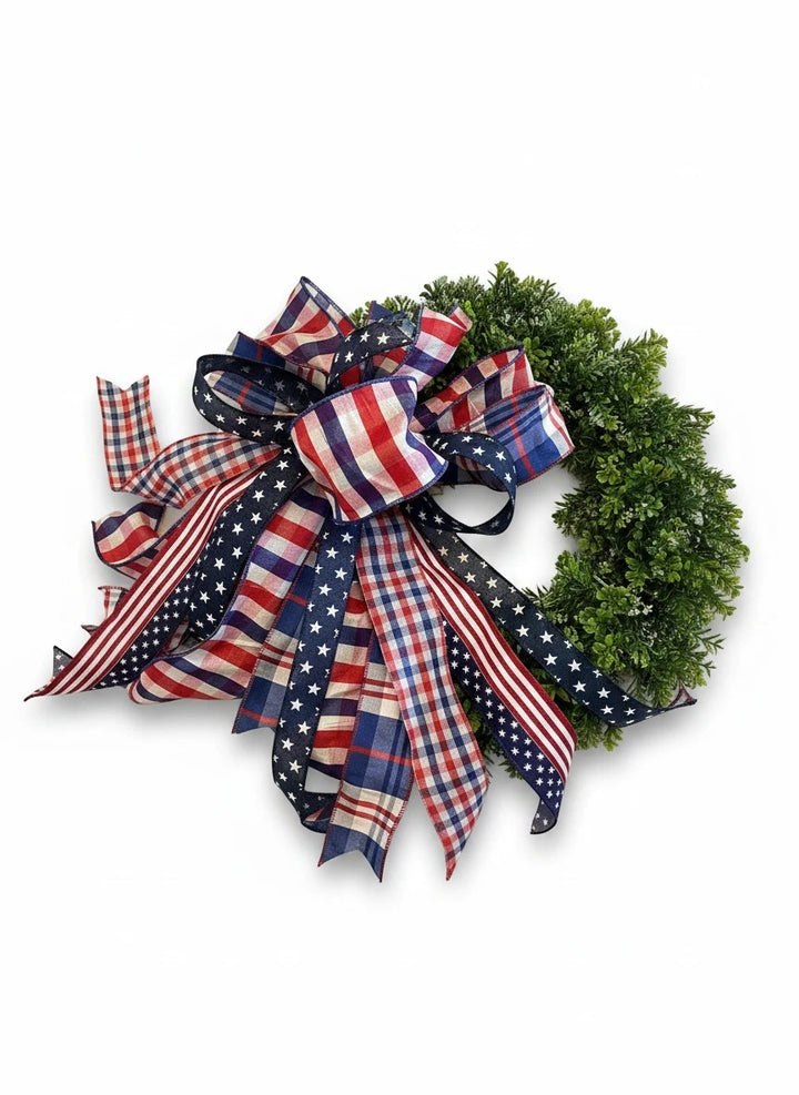 Chic Collective patriotic bow with red, white, and blue plaid and stars ribbons on a green wreath.