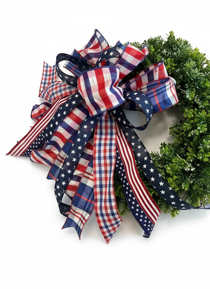Chic Collective patriotic bow with red, white, and blue plaid and stars ribbons on a green wreath.