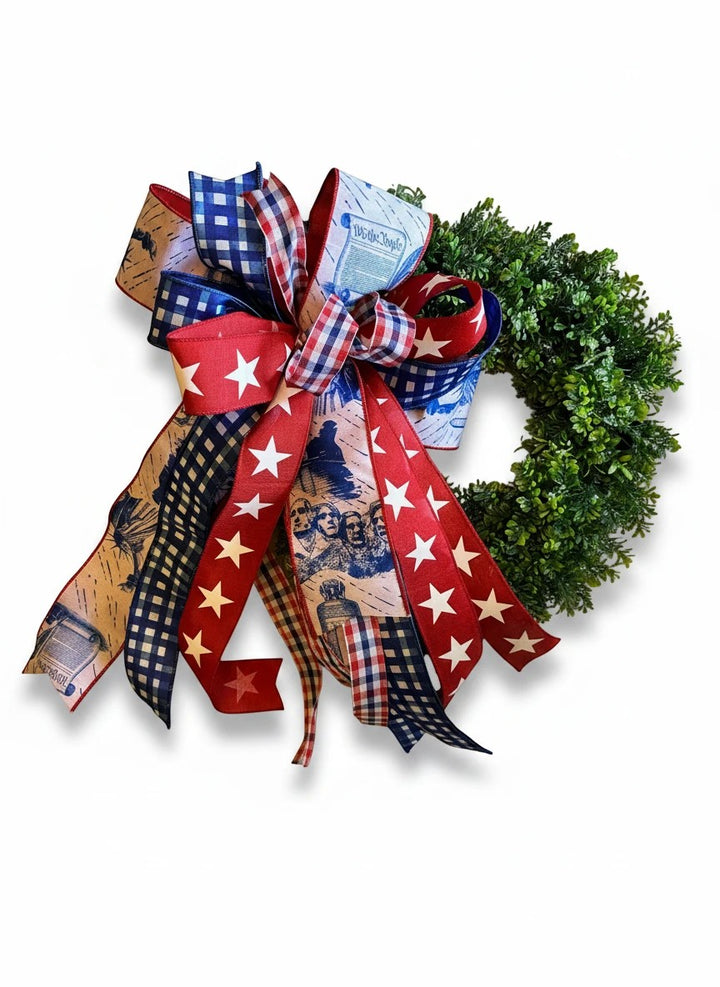 Chic Collective patriotic wreath bow with red, white, and blue ribbons featuring stars, gingham, Mount Rushmore, and "We the People" text.