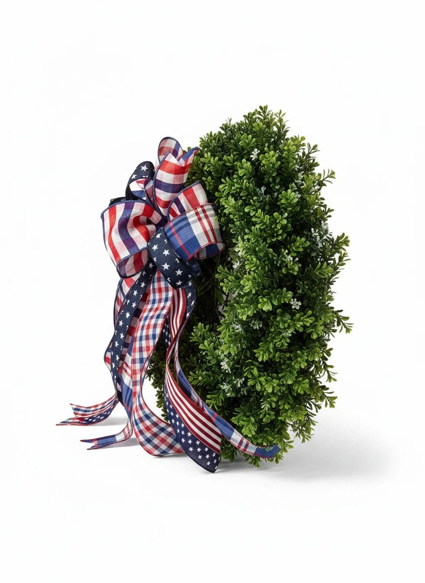 Chic Collective patriotic wreath with a large bow made of red, white, and blue plaid and star-patterned ribbons.