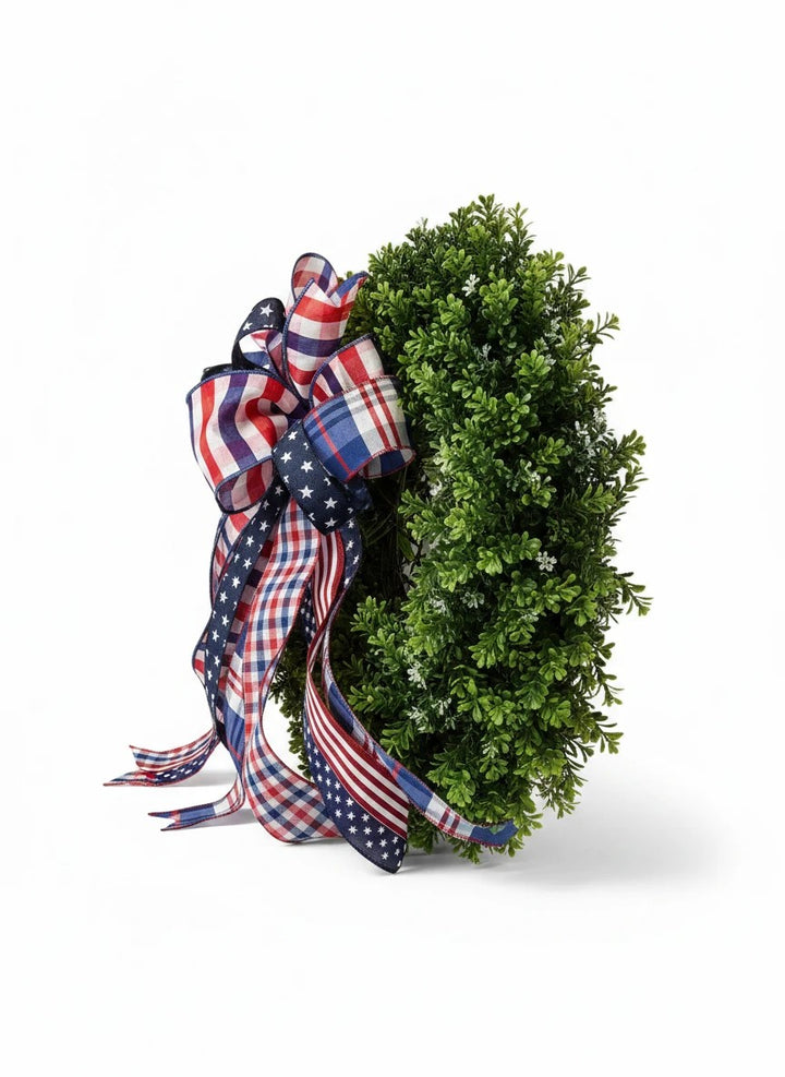Chic Collective patriotic wreath with a large bow made of red, white, and blue plaid and star-patterned ribbons.