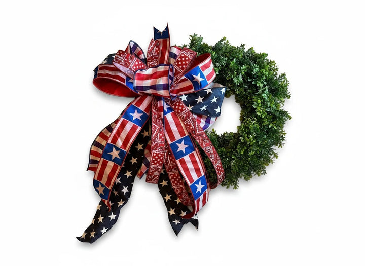 Chic Collective patriotic bow with American flag and stars pattern ribbons on a green wreath.