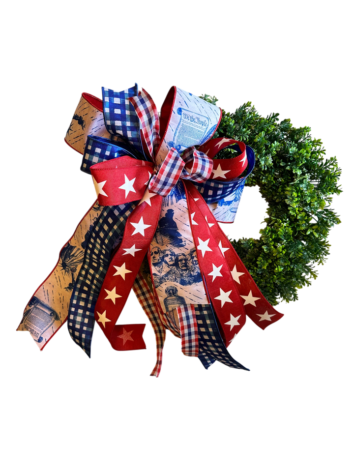 Chic Collective patriotic wreath bow with red, white, and blue ribbons featuring "We the People" text, Mount Rushmore, and stars.
