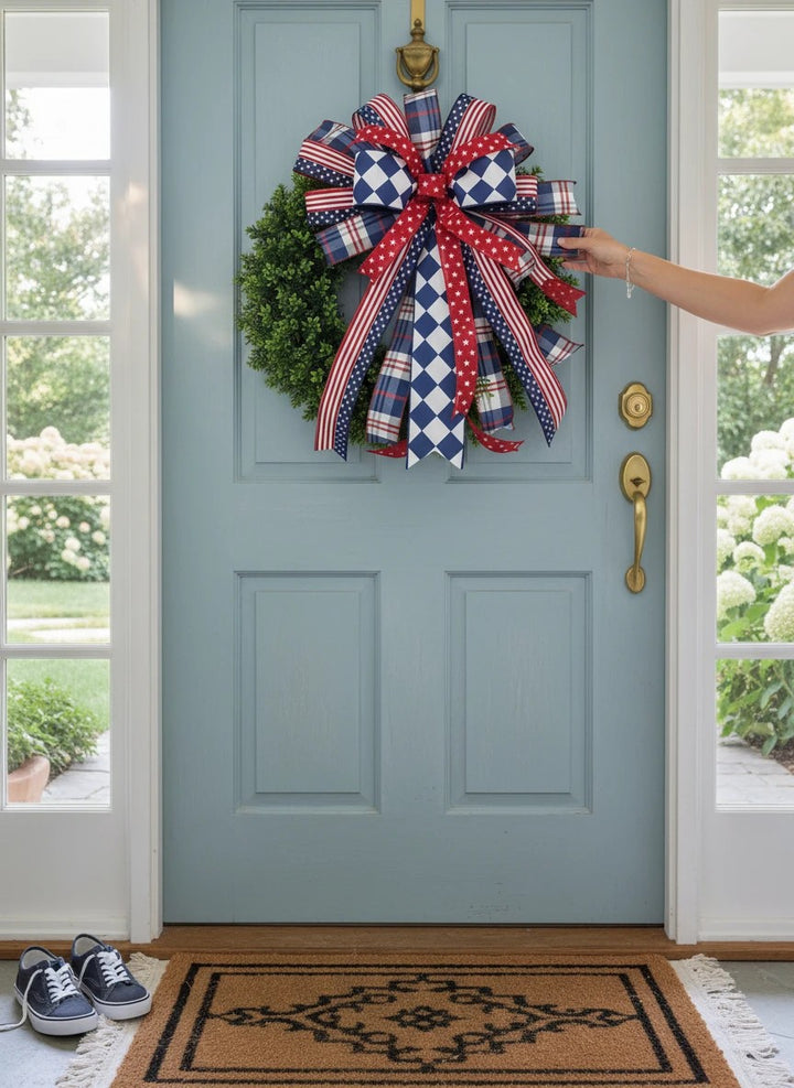 Chic Collective patriotic bow with red, white, and blue ribbons on a green wreath.