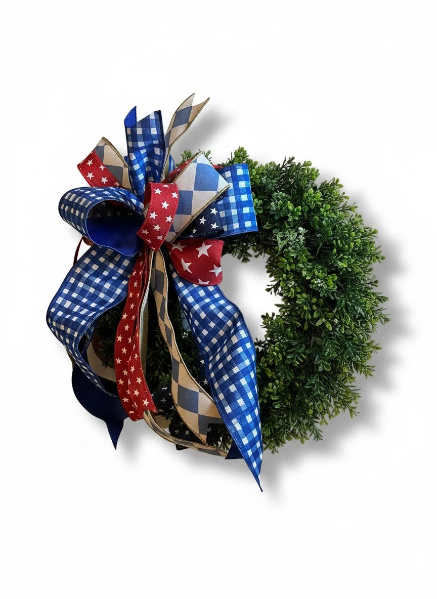 Chic Collective patriotic bow with red, white, and blue ribbons on a green wreath.