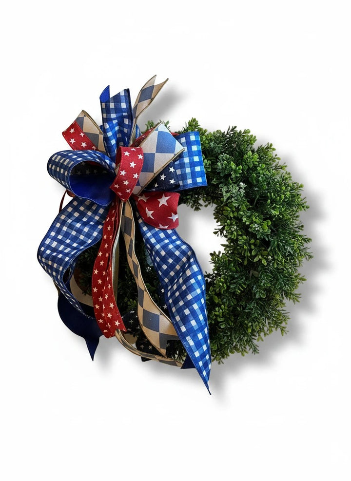Chic Collective patriotic bow with red, white, and blue ribbons on a green wreath.