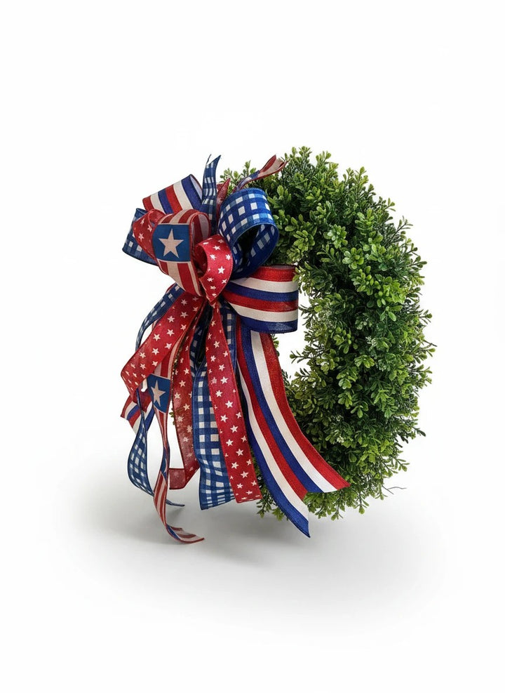 Chic Collective patriotic bow with red, white, and blue ribbons featuring stars and gingham patterns on a green wreath.