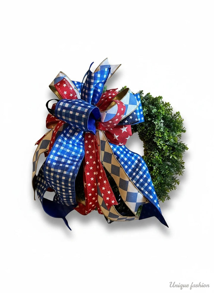 Chic Collective patriotic bow with red, white, and blue ribbons featuring stars and gingham patterns, attached to a small green wreath.