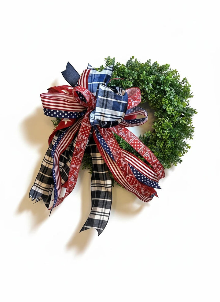 Chic Collective patriotic bow with red, white, and blue ribbons featuring stars and plaid patterns on a green wreath.